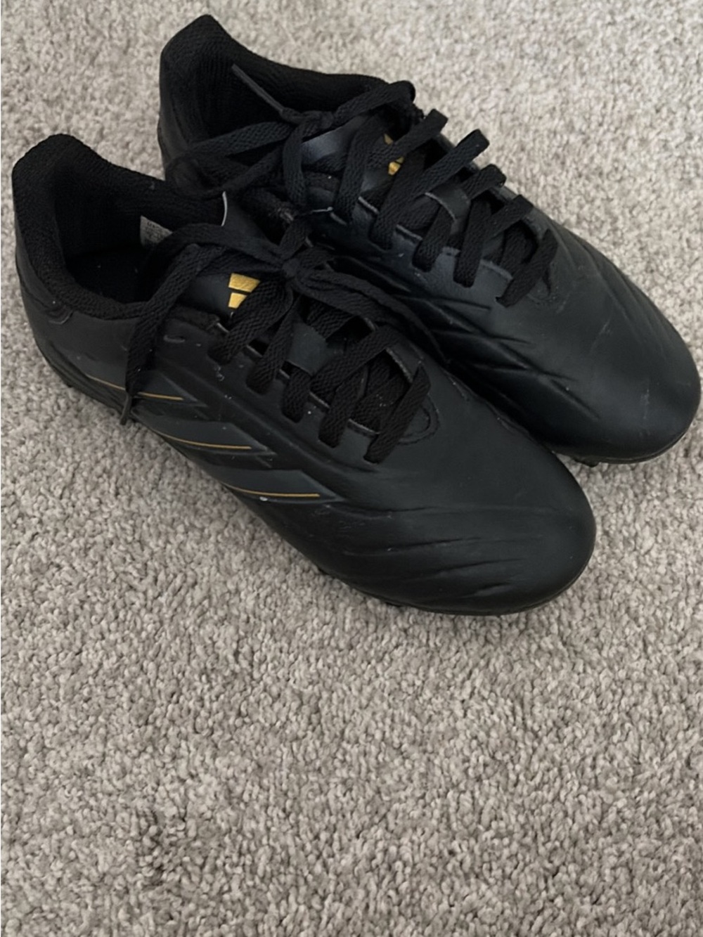 adidas kid’s Black Athletic Soccer Shoes with Gold Accents